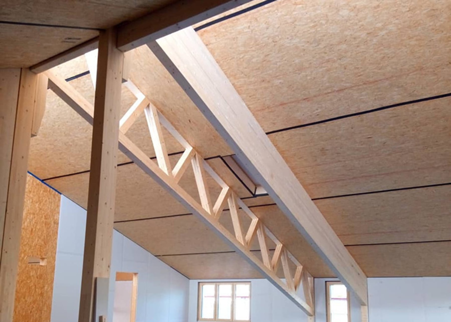 Innenaufnahme Holzbau mit Deckenträgern und OSB-Platten